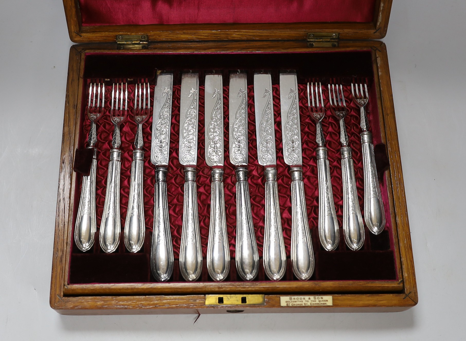 An oak cased Brook & Son ornate plated fruit set of knives and forks